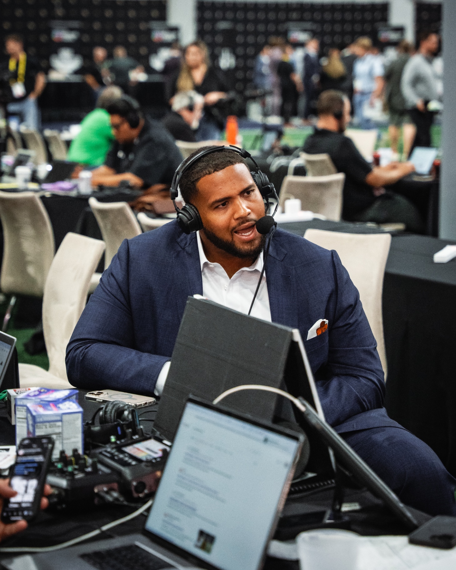 Ben Coleman in navy suit wearing broadcast headset