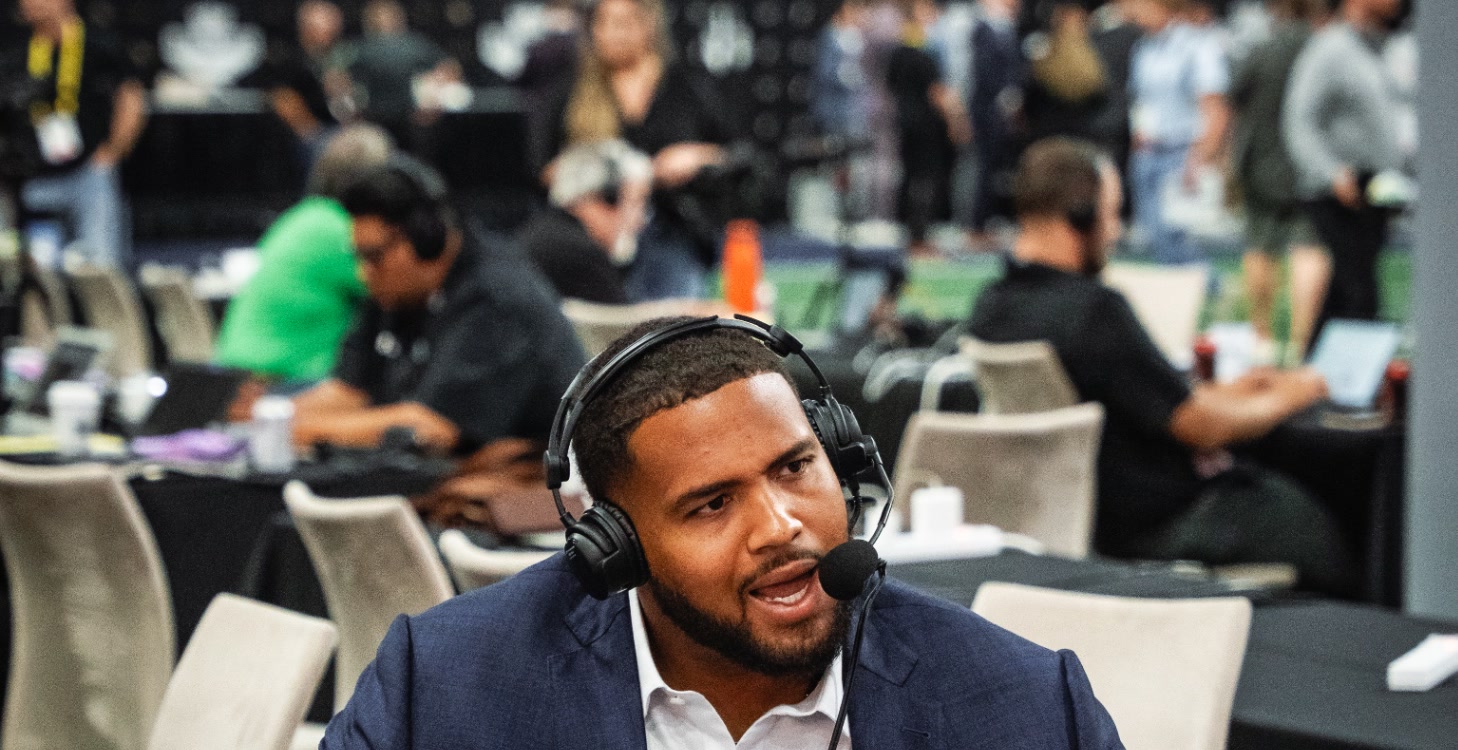 Ben Coleman in navy suit wearing broadcast headset
